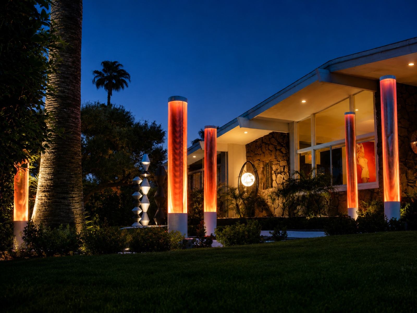 Mid-century home and landscape lit with warm ember columns at dusk